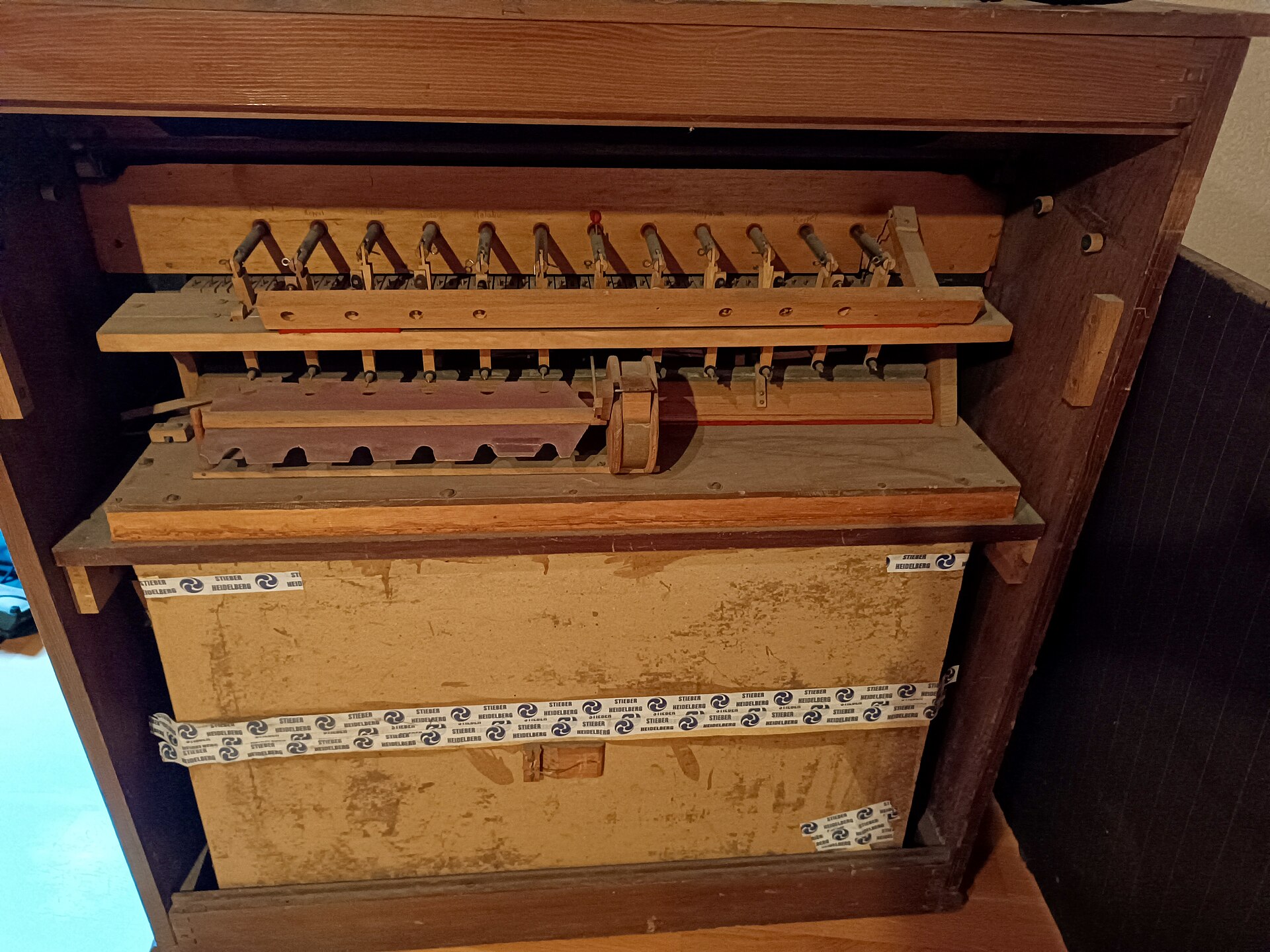 An antique music box mechanism with wooden components is shown, relating to the film soundtrack tradition.