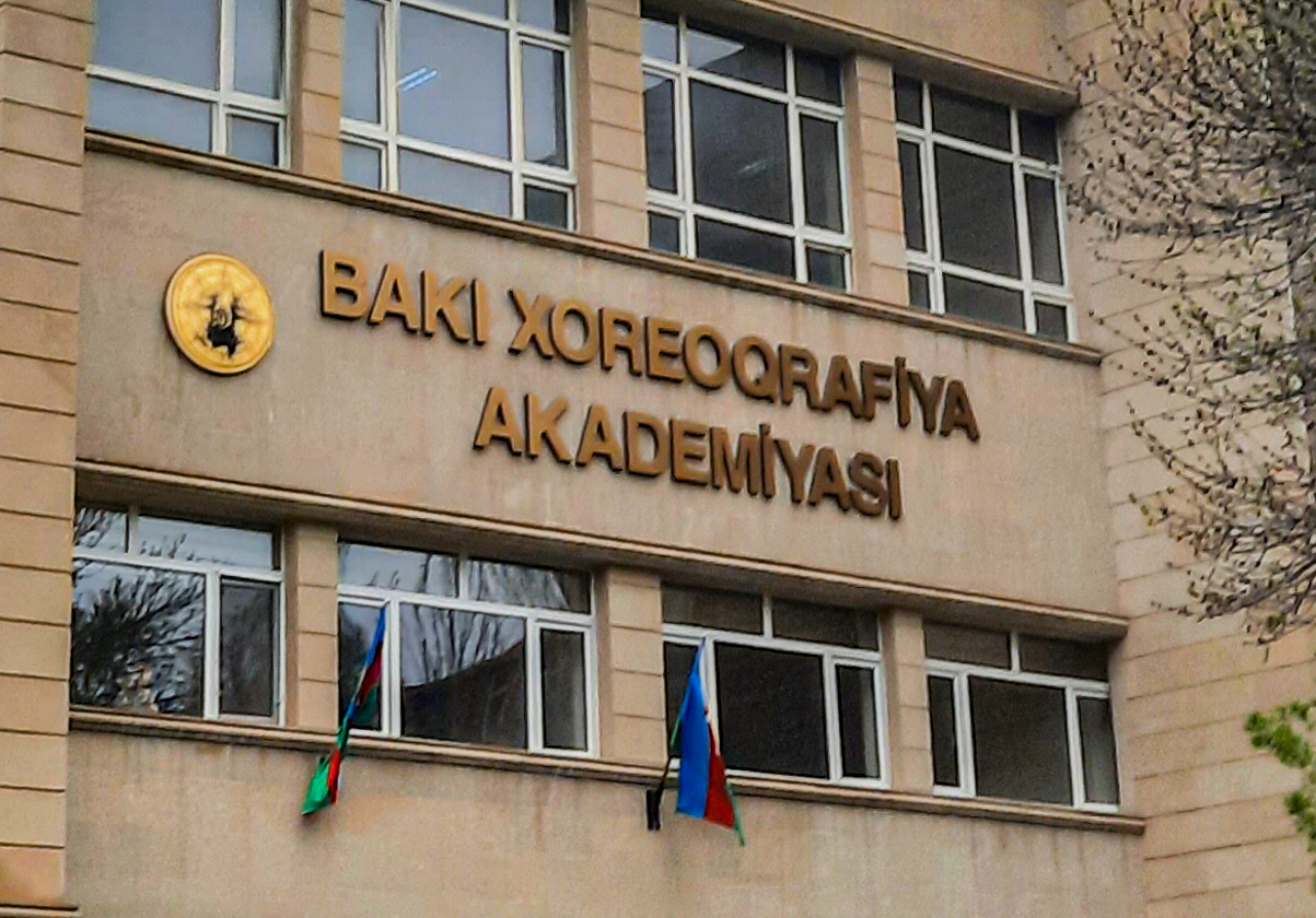 The Baku Choreography Academy building in Azerbaijan displays signage and national flags.