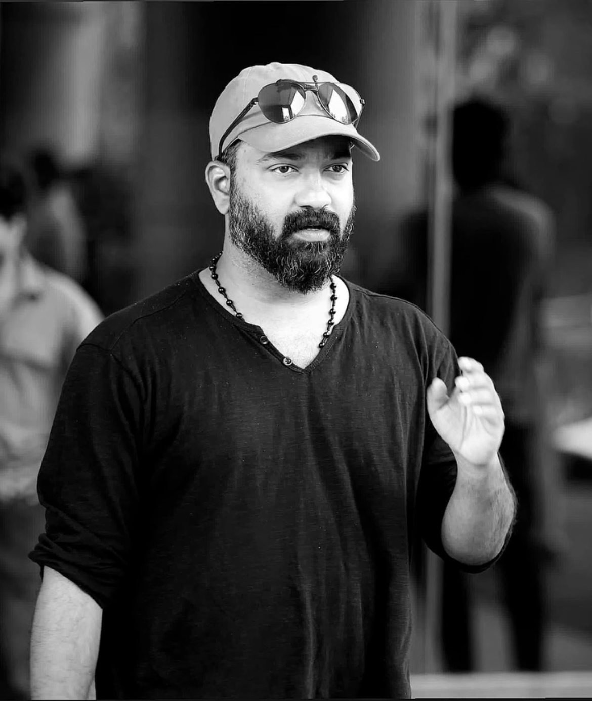 A man with a beard wearing a cap and sunglasses, representing early indian cinema history.